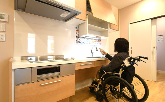 吊戸棚が下がった状態のキッチン。座った姿勢でも無理なく物を出し入れできる高さになっている。