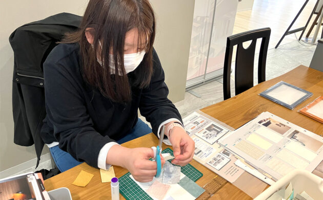選んだ壁紙を切って台紙に貼る様子